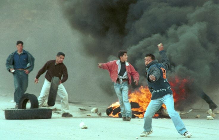 **FILE** Young Palestinian men burn tires and throw rocks when clashing with Israeli army in the West Bank city of Ramallah, during the first intifada. March 28, 1997. Photo by Nati Shohat/Flash90 *** Local Caption *** ???????? ?????? ???????? ???? ??? ??? ???? ????? ???? ???????? ??? ????? ????? ??????? ?????? ?????? ???????? ????????? ??????? ???????? ???????? ????????? ??????? ???????? ??????? ???????? ??????? ???????? ???????? ????????? ???????? ????????? ???????? ????????? ???????? ??????? ???????? ??????? ????????? ???????? ??"? ??"?