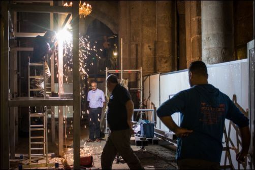 A man welds a structure near other construction workers in the Holy Church of the Sepulchre, May 29, 2016. Photo by Zack Wajsgras/Flash90